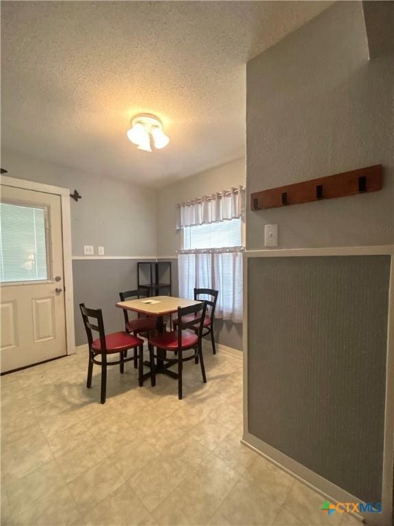 dining room with light floors and a textured ceiling