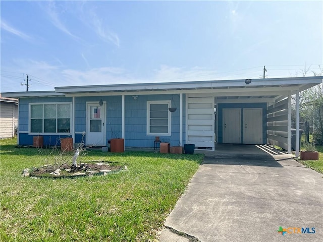 view of front of house with an attached carport, driveway, and a front lawn