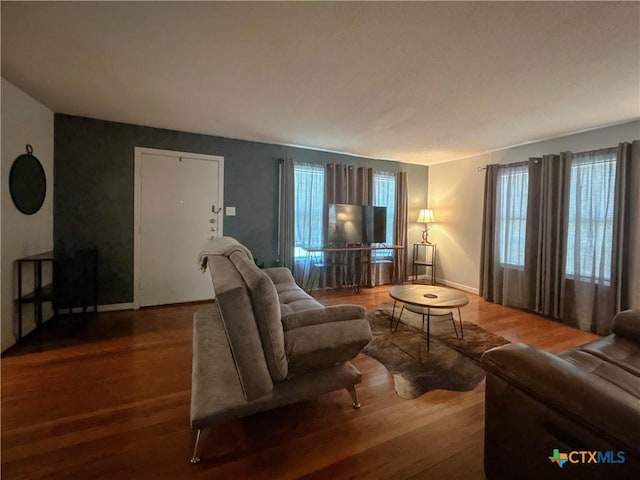 living area with baseboards and wood finished floors