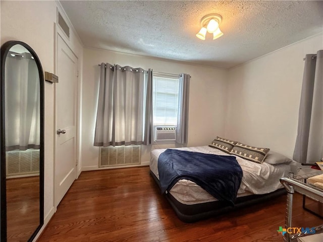 bedroom with cooling unit, wood finished floors, and visible vents