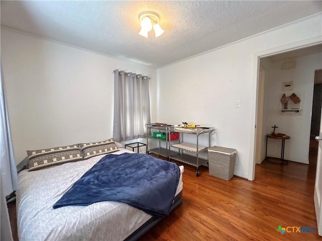 bedroom featuring a textured ceiling and wood finished floors