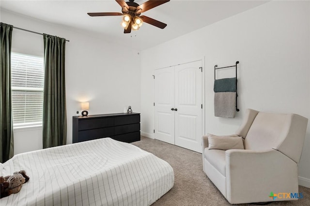 bedroom with light carpet, ceiling fan, and a closet