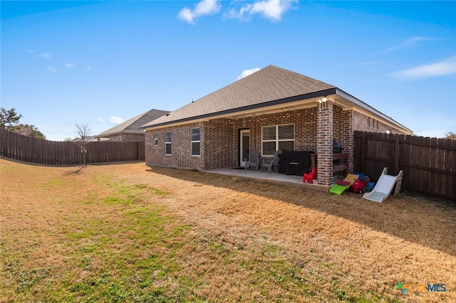 back of house with a lawn and a patio