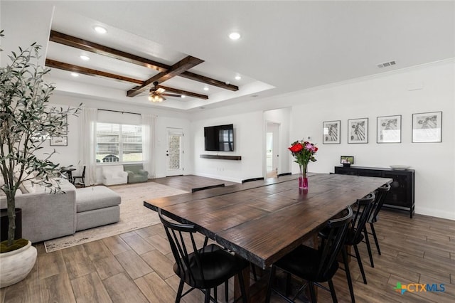 dining area with dark wood-type flooring, ceiling fan, and beam ceiling