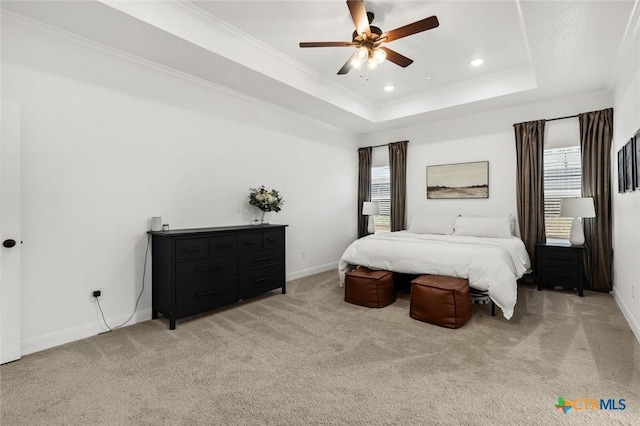 bedroom with crown molding, ceiling fan, a tray ceiling, and carpet floors