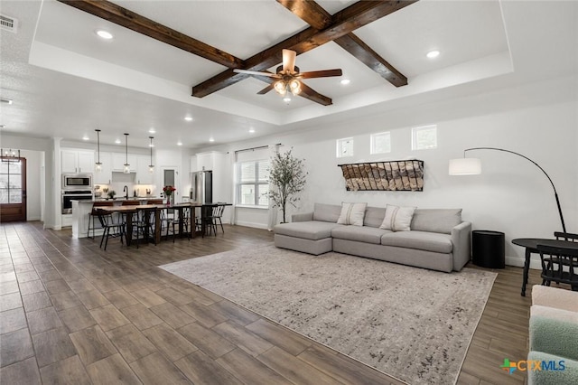 living room with beamed ceiling, dark hardwood / wood-style floors, and ceiling fan