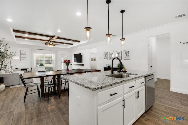 kitchen with sink, light stone countertops, white cabinets, a center island with sink, and stainless steel dishwasher