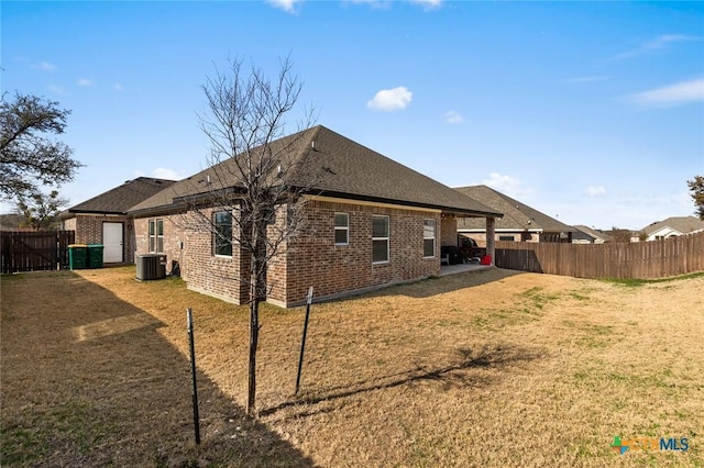 back of property with a yard, central AC unit, and a patio