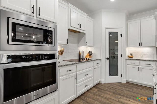 kitchen featuring white cabinetry, appliances with stainless steel finishes, dark hardwood / wood-style floors, and light stone counters