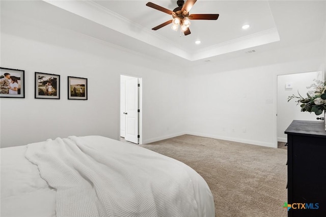 carpeted bedroom with crown molding, ceiling fan, and a tray ceiling