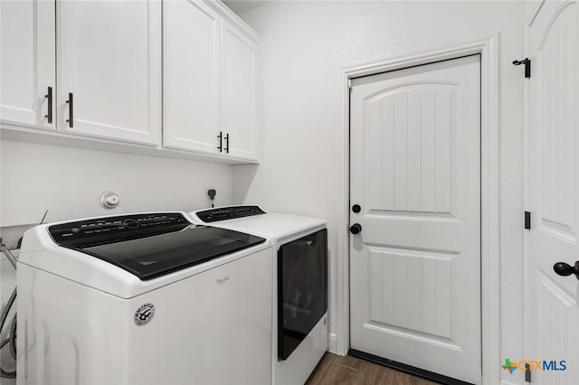 clothes washing area with dark hardwood / wood-style flooring, cabinets, and independent washer and dryer