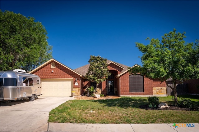 ranch-style home with a garage, brick siding, a front lawn, and driveway