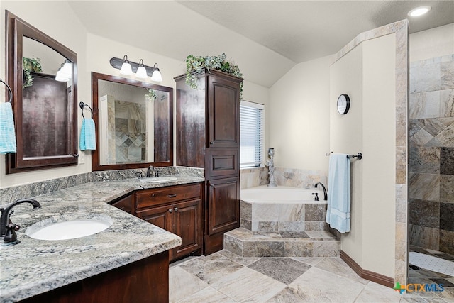 full bathroom with a bath, a walk in shower, vaulted ceiling, and vanity