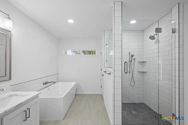 bathroom with vanity, a shower stall, recessed lighting, and a freestanding bath