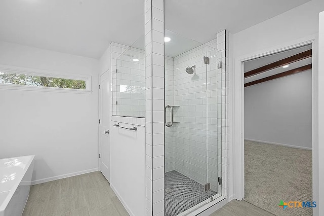 full bath with baseboards, a shower stall, and a bathing tub