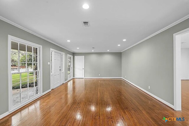 spare room featuring visible vents, wood finished floors, recessed lighting, crown molding, and baseboards