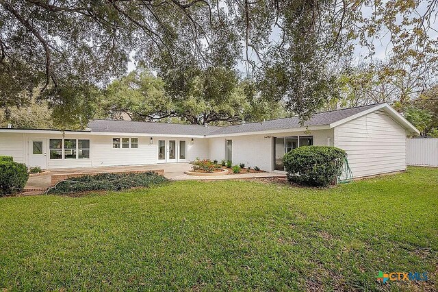 back of house with a patio, french doors, and a lawn