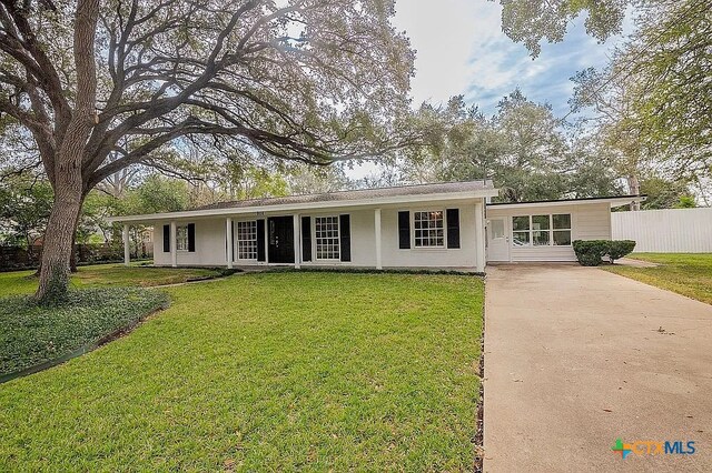 ranch-style house with driveway, a front lawn, and fence