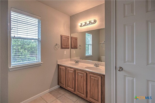 117 Lone Shadow Dr, Harker Heights, TX 76548 - bathroom featuring tile patterned flooring, plenty of natural light, a textured wall, double vanity, and baseboards