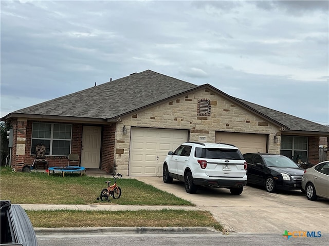 single story home featuring a front lawn and a garage