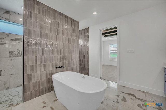 bathroom featuring vanity, separate shower and tub, and tile walls