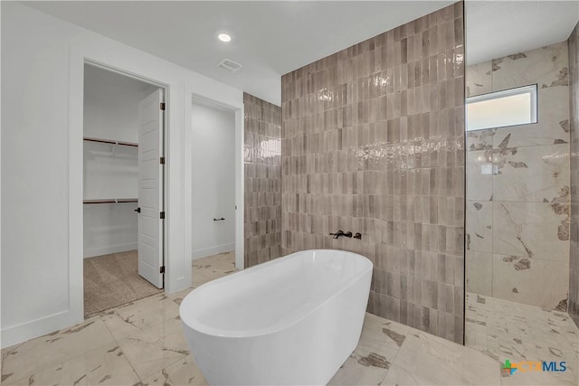 bathroom featuring tile walls and independent shower and bath