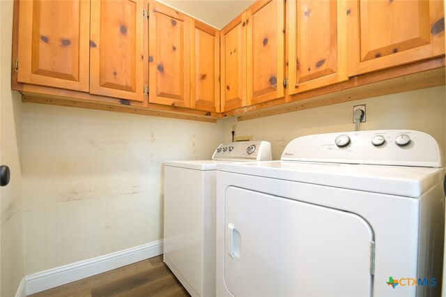 laundry room with cabinets, dark hardwood / wood-style floors, and washing machine and clothes dryer