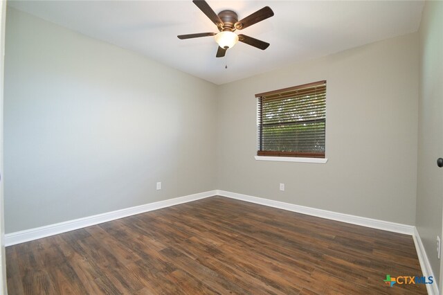 empty room with ceiling fan and dark hardwood / wood-style flooring