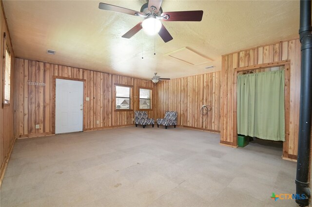 miscellaneous room featuring ceiling fan and wooden walls