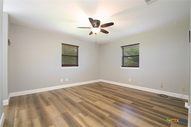 spare room with ceiling fan and dark wood-type flooring