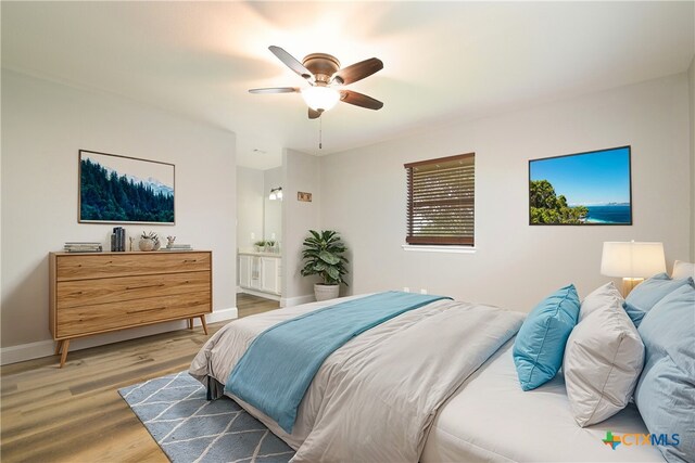 bedroom featuring hardwood / wood-style flooring, ceiling fan, and ensuite bath