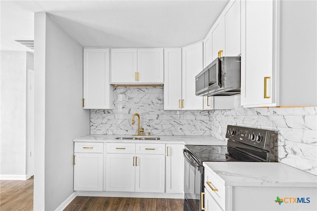 kitchen featuring black electric range oven, a sink, white cabinetry, stainless steel microwave, and dark wood-style flooring