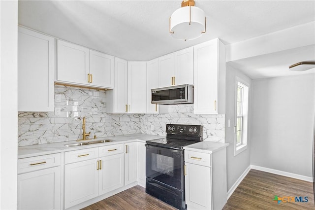 kitchen featuring white cabinets, a sink, black / electric stove, and stainless steel microwave