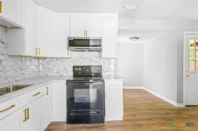 kitchen with baseboards, black / electric stove, stainless steel microwave, and tasteful backsplash