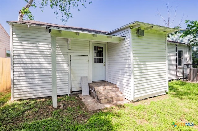rear view of property with fence and a yard