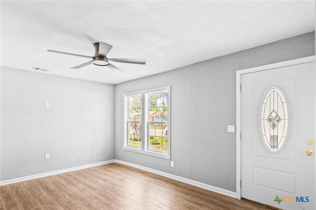 foyer entrance featuring wood finished floors, visible vents, baseboards, and ceiling fan