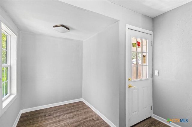 doorway featuring dark wood finished floors and baseboards