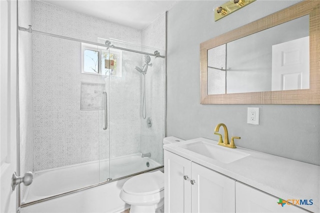 bathroom featuring combined bath / shower with glass door, toilet, and vanity