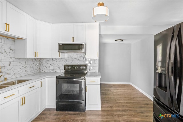 kitchen with backsplash, white cabinets, black appliances, dark wood finished floors, and baseboards