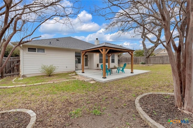 rear view of property featuring a gazebo, a patio, a lawn, and a fenced backyard