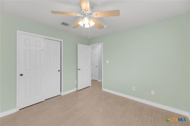 unfurnished bedroom with visible vents, light wood-style flooring, a closet, baseboards, and ceiling fan