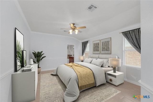 bedroom featuring light wood-type flooring, visible vents, baseboards, and ornamental molding