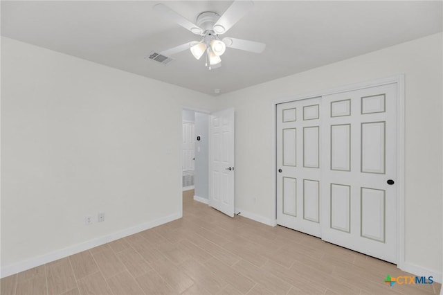 unfurnished bedroom with light wood finished floors, visible vents, baseboards, a closet, and a ceiling fan