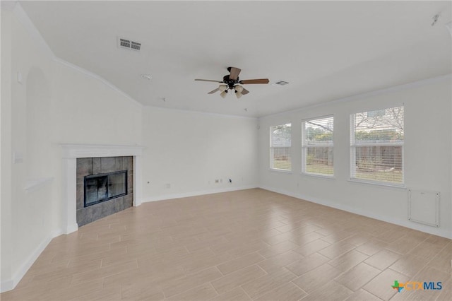 unfurnished living room with a tiled fireplace, wood finish floors, visible vents, and ceiling fan