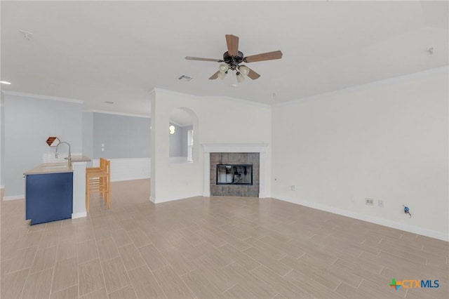 unfurnished living room with a sink, baseboards, ceiling fan, and wood tiled floor