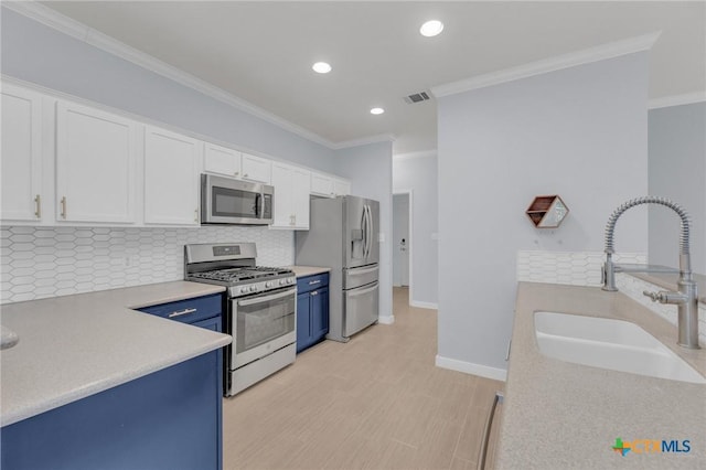 kitchen with visible vents, a sink, white cabinets, appliances with stainless steel finishes, and blue cabinets