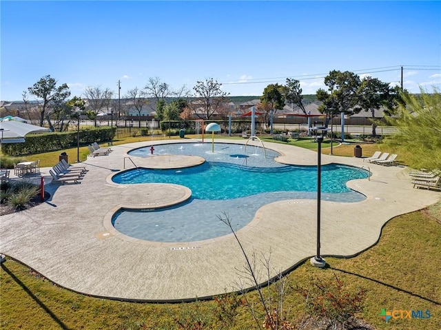 view of swimming pool with a patio, a yard, and fence