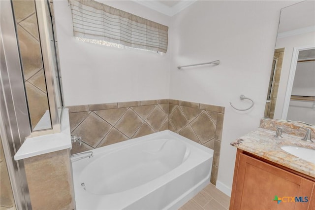 full bath with vanity, a garden tub, and crown molding