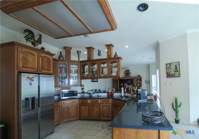 kitchen with kitchen peninsula, sink, appliances with stainless steel finishes, and ornamental molding