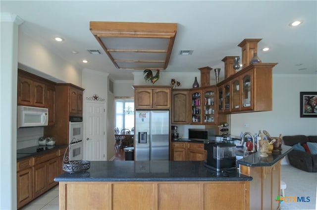 kitchen featuring kitchen peninsula, stainless steel fridge, light tile patterned floors, and crown molding